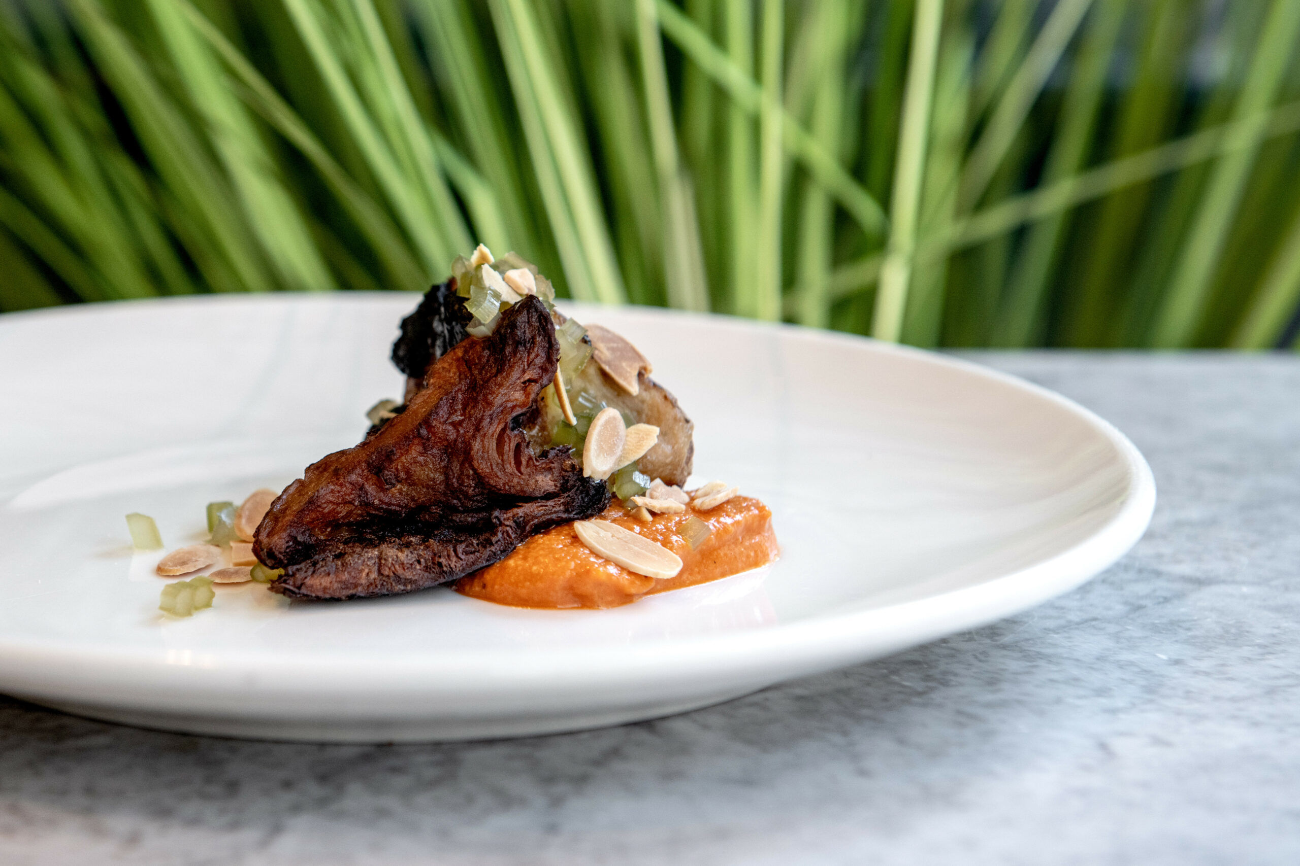 meat dish served on the white round table with the plant background at Kindling Brighton