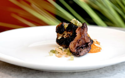 meat dish served on the white round table with the plant background at Kindling Brighton