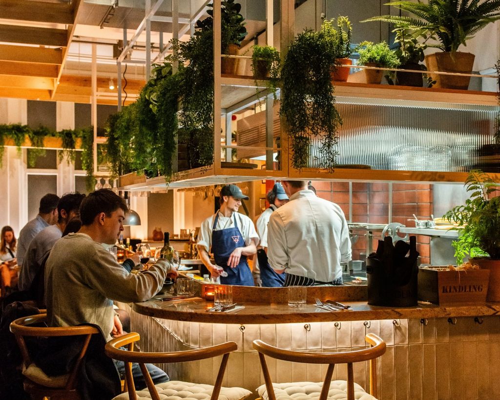 Diners enjoying the whole experience at this steak restaurant in brighton. Customers sat at an open plan kitchen. 