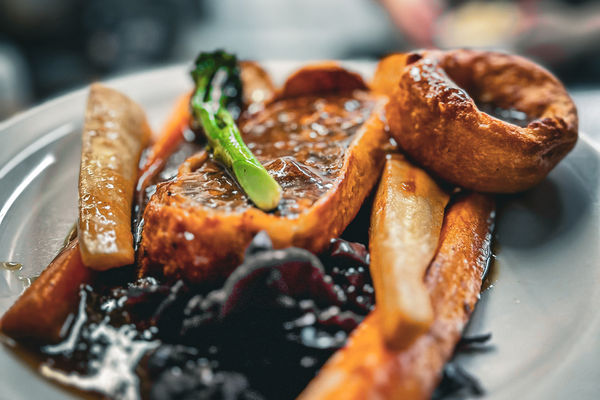 A close up photo of the ingredients on a vegan Sunday roast with a yorkshire pudding, veg and seitan.