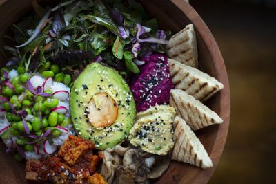 A colourful buddha bowl with avocado, greens and tofu