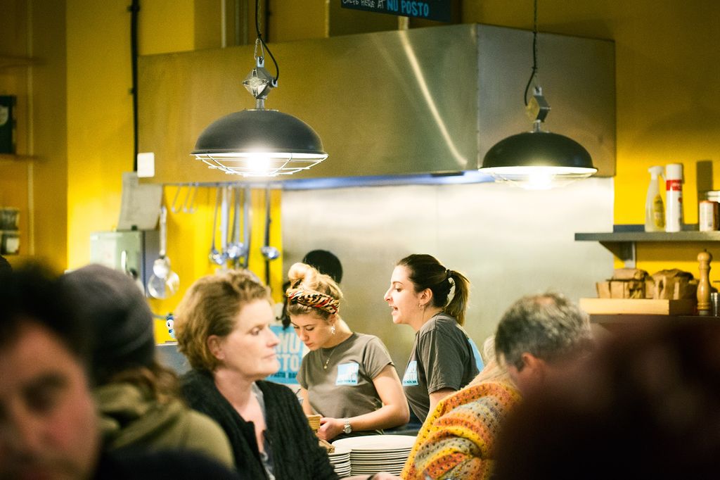 Italian restaurant interior and staff members serving diners