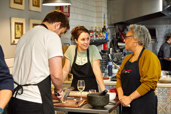 few people chatting over cooking table at Brighton Cookery School