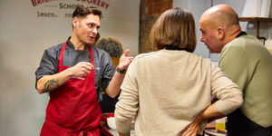 Chef Victor talking to the couple during cooking class at Brighton Cookery School
