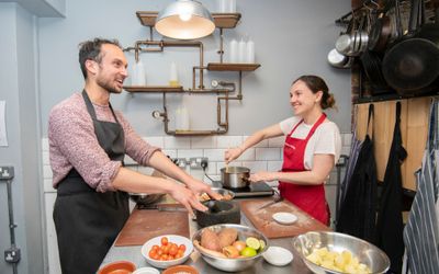 happy cooking couple enjoying their class while smiling and cooking