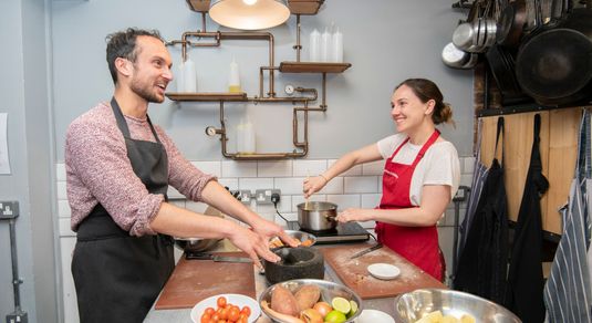 happy cooking couple enjoying their class while smiling and cooking