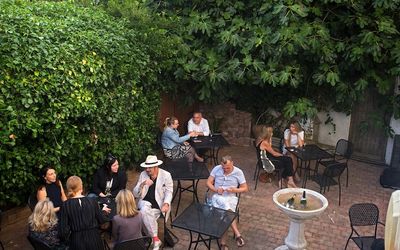 The courtyard garden surrounded by trees with people sitting enjoying drinks