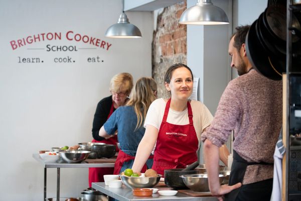 shot of the woman smiling and looking at the man during brighton cookery school cooking class