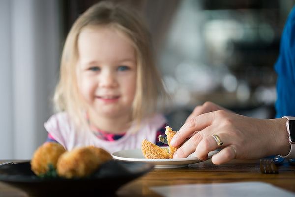 Arancini being served on a plate with a happy child