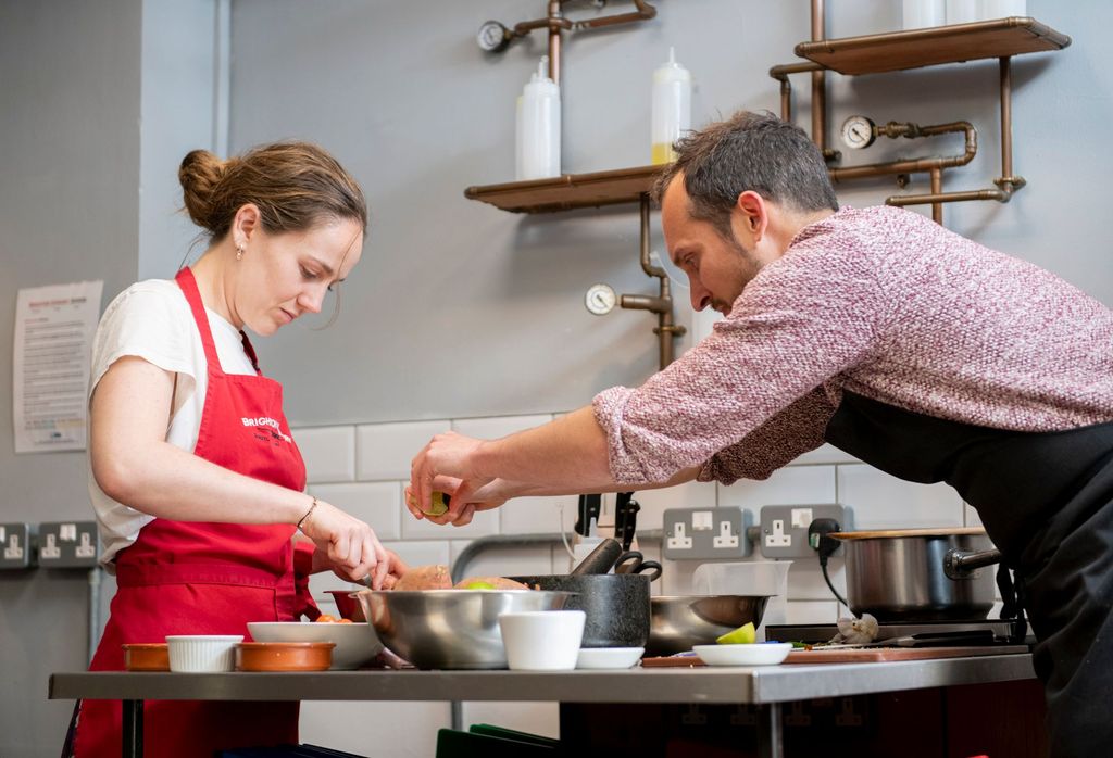 Cookery Classes Brighton - cooking couple adding some spices to their dishes during cooking class at the brighton cookery school. Christmas gift ideas