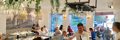 Interior shot of busy restaurant with white and botanical themed interorios