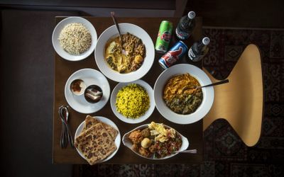 Overhead shot of Indian feast including curries, rice, naan and drinks