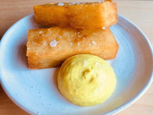 Two rectangular pieces of lamb fat confit potato are next to a generous dollop of yellow curry leaf mayo at Kitgum Brighton