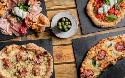 over head shot of the table at VIP pizza laid out with Italian pizzas and sandwiches