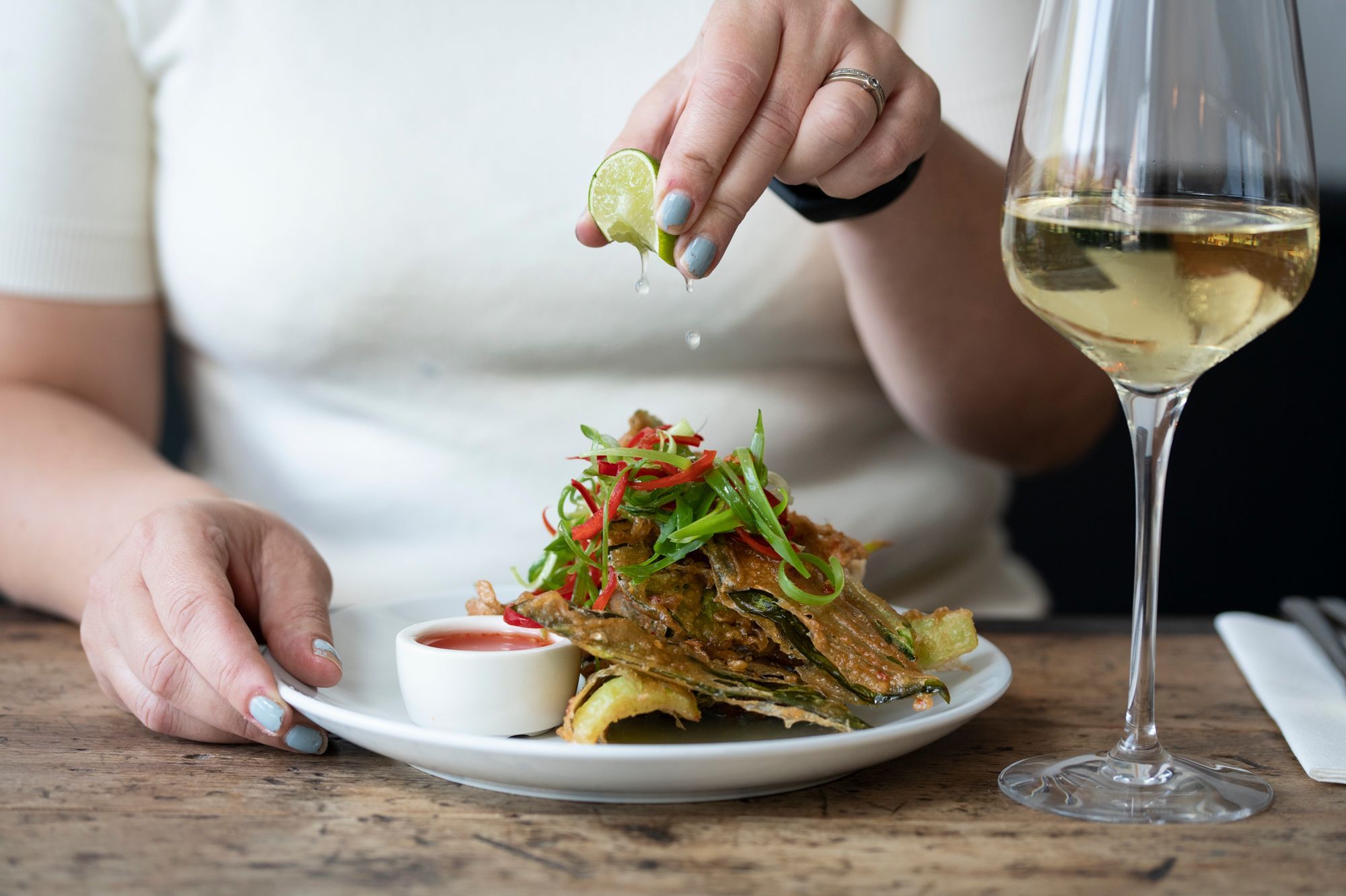 hands squeezing lime on the dish