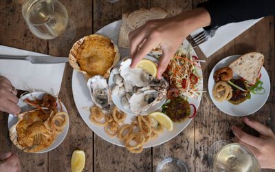 hand holding lemon above 3 Irish rock oysters