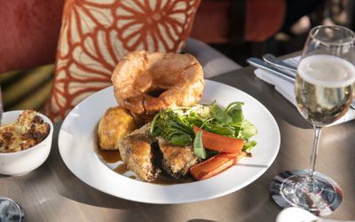 Sunday roast with a giant yorkshire pudding and a glass of white wine.