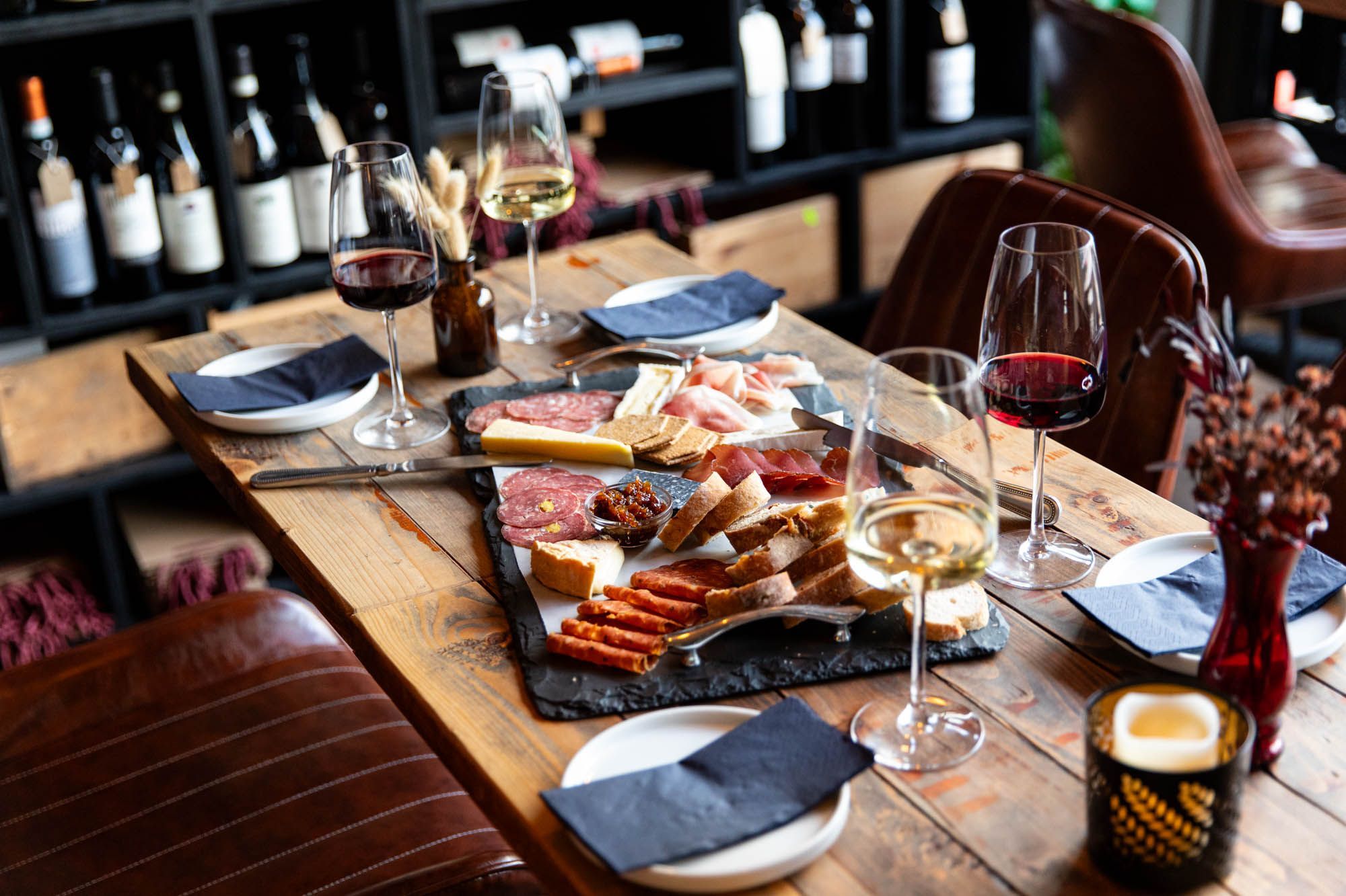 table laid out with charcuterie and cheese board, and glasses of red and white wine at Cases Hove