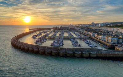 A sunset view of Brighton Marina with the sea, sky and Brighton in the background.