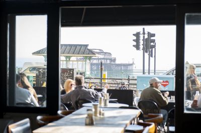 A view of the West pier taken from inside The New Club, looking through the open glass doors at alfresco diners