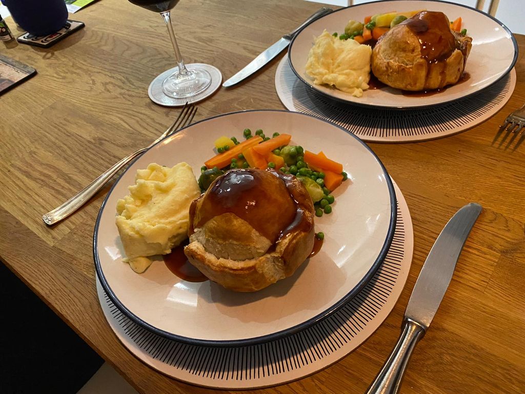 two plates of handmade pie served with mash and mixed vegetables