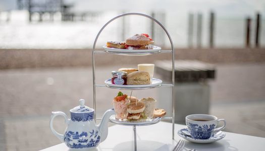 Alfresco afternoon tea on the beach with a view of the West Pier on the Coronation 2023 weekend.