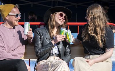 People enjoying cans of craft beer outside on a sunny day