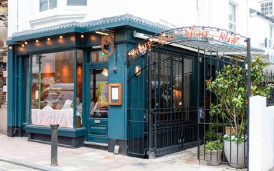 entrance to burnt orange Brighton. The entrance goes through their courtyard which is an alfresco area. The facade is dark blue. Burnt Orange could also be considered a wine bar Brighton, Brighton restaurant, Brighton cocktails.