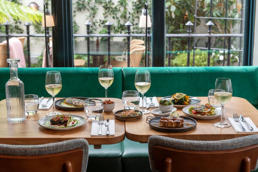 Table next to big window laid out with small plates and drinks. Burnt Orange, winner of best restaurants Brighton in BRAVO Awards 2023. Brighton's best restaurant in 2023. The Lanes Brighton. Best restaurants Brighton winner.