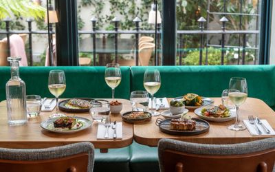 Table next to big window laid out with small plates and drinks. Burnt Orange, winner of best restaurants Brighton in BRAVO Awards 2023. Brighton's best restaurant in 2023. The Lanes Brighton. Best restaurants Brighton winner.