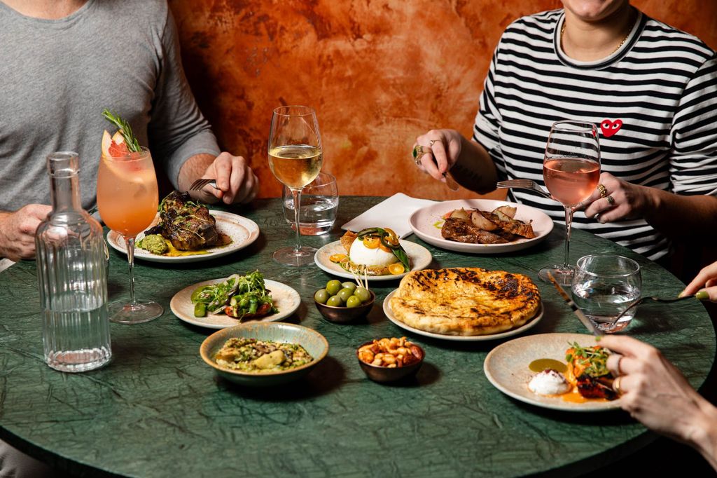 group of friends enjoying small plates and cocktails at Burnt Orange Brighton
