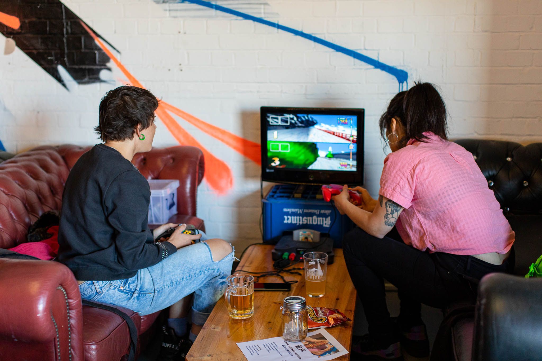 two girls playing games at the gaming station at the brigton brewery