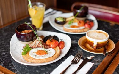 A table laid out with two large Full English breakfasts coffee and juice