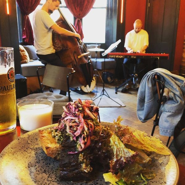 Brisket served with glass of beer and jazz singer in backgroud
