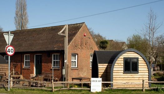 A red brick classic country pub with a wooden dining cabin at the front