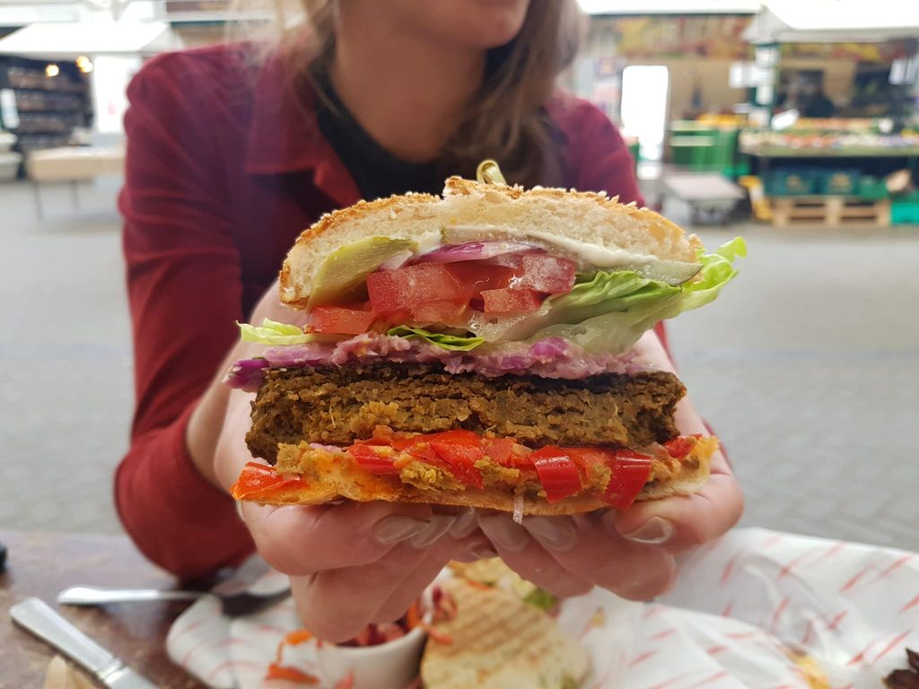 hands holding out half a vegan burger