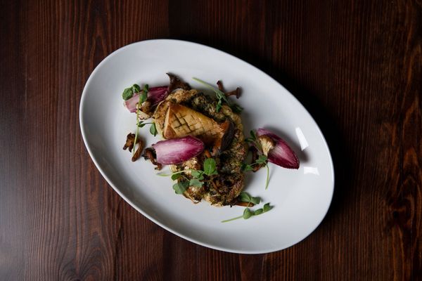 meat dish served on oval white plate, bird perspective