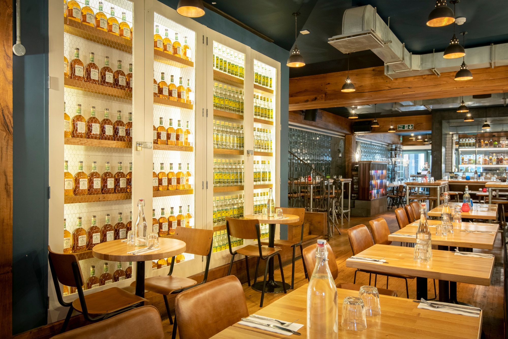 interior of Caribbean bar and restaurant, wooden furniture with big shelves of rum storage