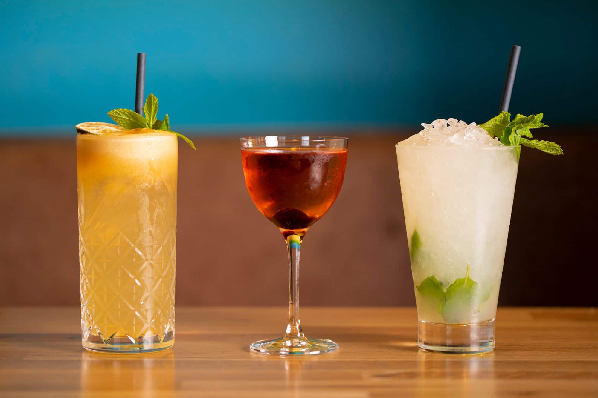 three glasses of different cocktails served on the wooden table at Rum Kitchen Brighton