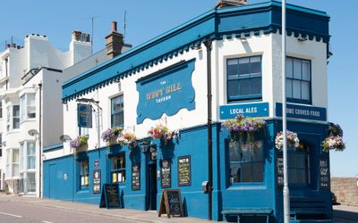 pub exterior. blue and white colored walls, flowers added as decoration