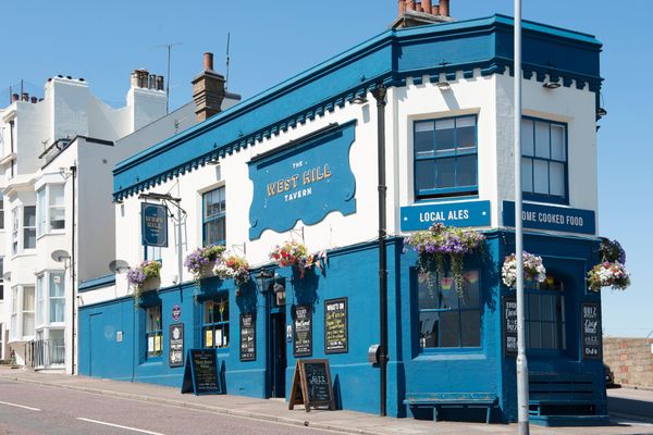 pub exterior. blue and white colored walls, flowers added as decoration
