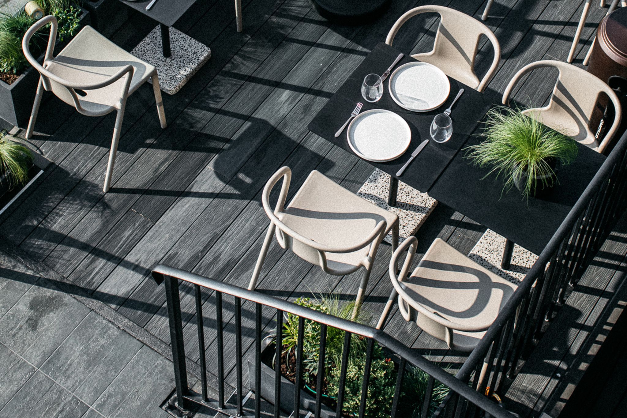 overhead shot of seating are at the port hotel, white chairs with the black tables with plant decoration