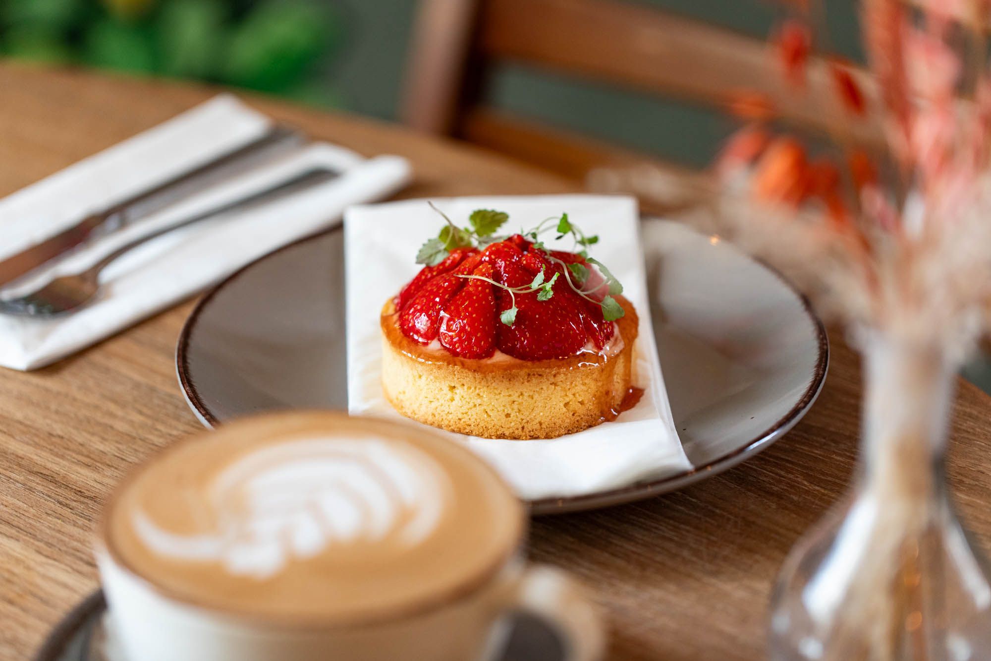 strawberry dessert with glass of flat white coffee at Post House Brighton