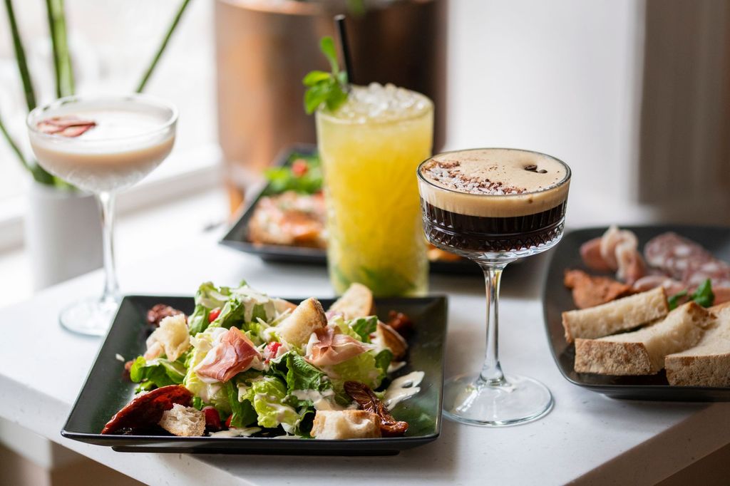 table laid out with orange cocktail espresso maritini and salad