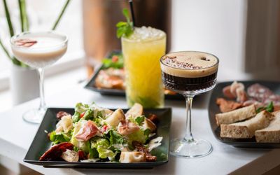 table laid out with orange cocktail espresso maritini and salad