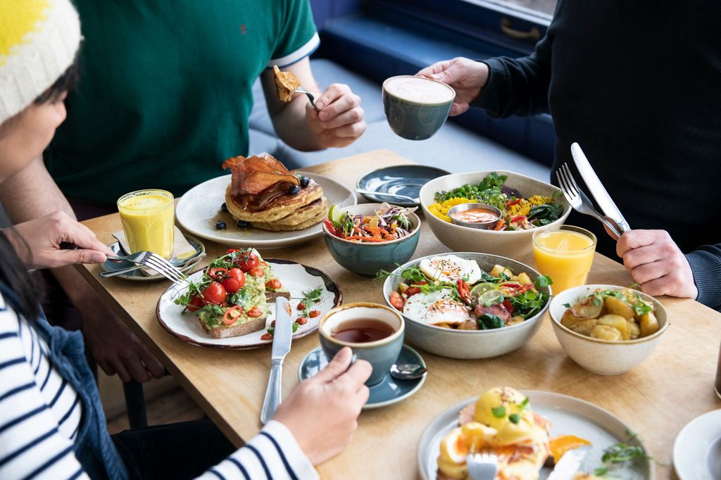 side shot of three people sitting and having brunch