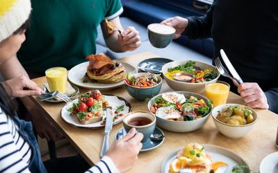 side shot of three people sitting and having brunch