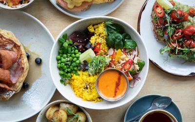 over head shot of table with dishes on focused on Buddha Brunch Bowl. Available for Brighton takeaway
