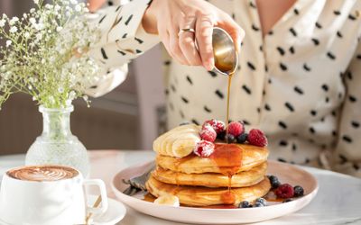 A stack of American pancakes covered with bananaa