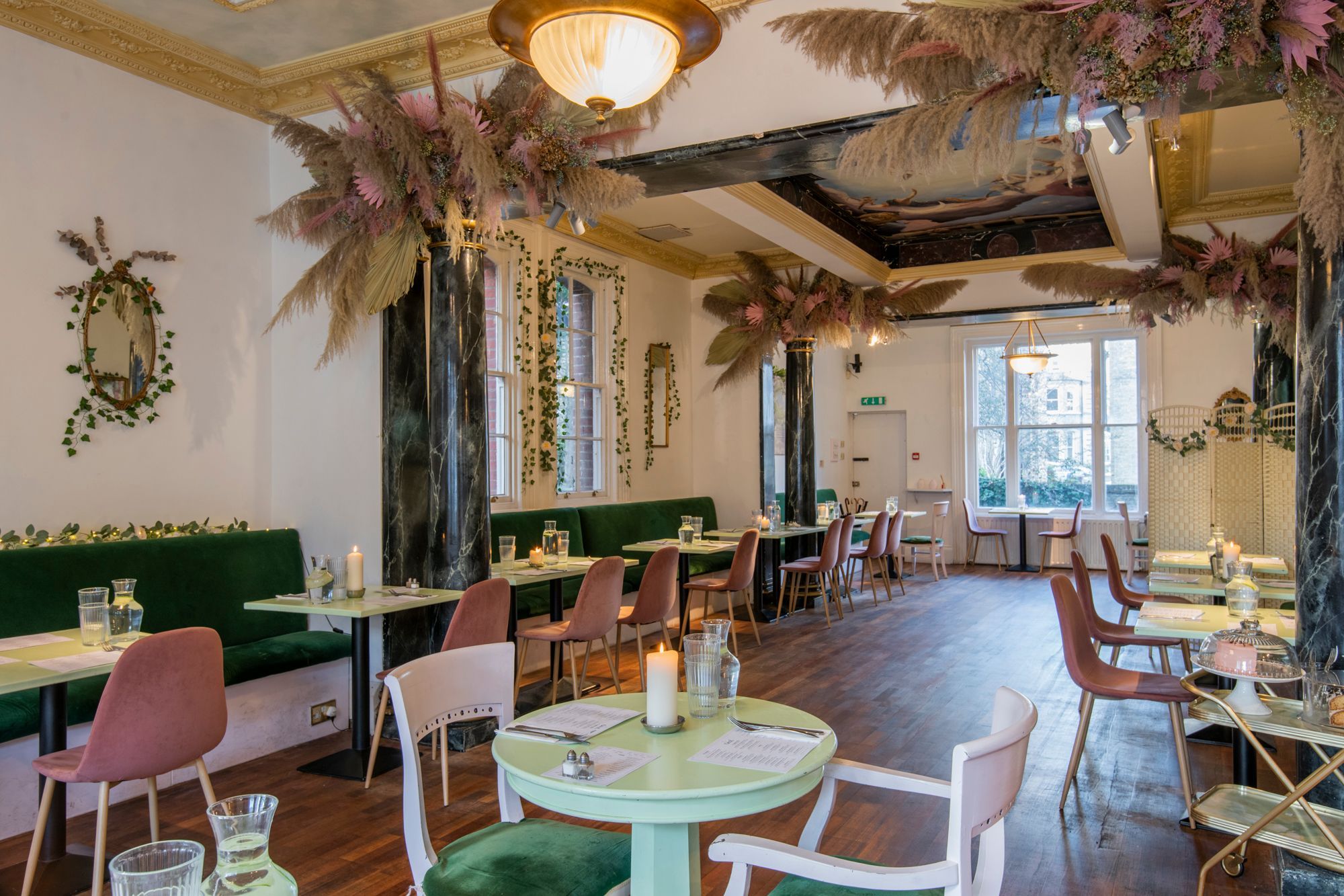 interior at in Hove cafe for an Oeuf experience. Decorated with dried flowers and brightly painted furnishings in pastel green.